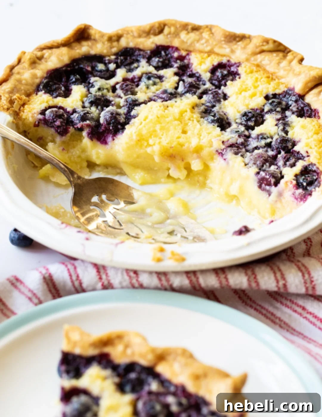 Blueberry Buttermilk Pie with several slices already cut and served.