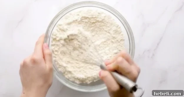 Whisking dry ingredients in a separate bowl.