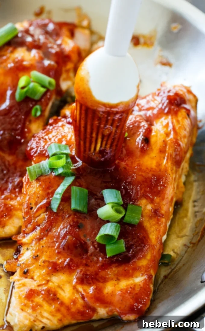 Salmon fillets searing in a pan before being transferred to the oven.