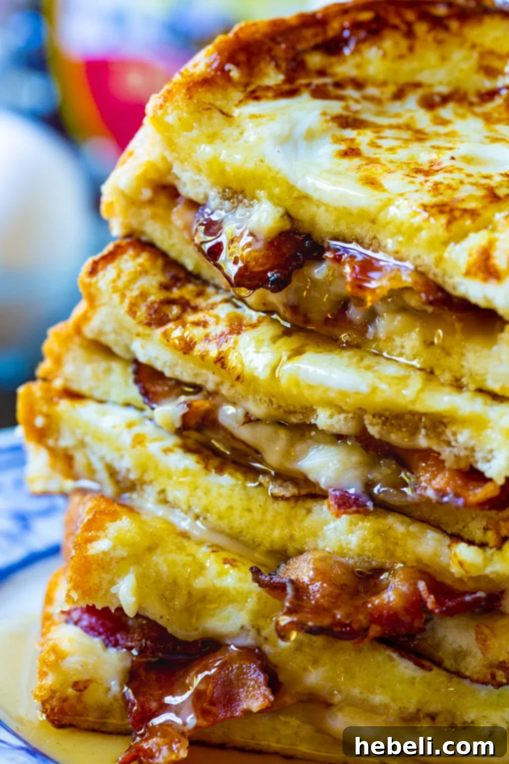 Detailed close-up of a stack of Bacon Stuffed French Toast, showcasing the crispy bacon and creamy filling peeking out