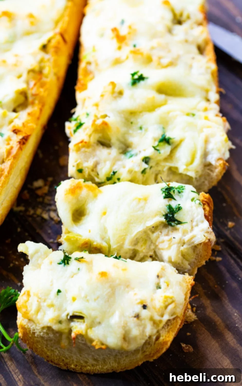 Artichoke and Crab Dip Bread cut into perfectly golden, cheesy slices, ready to be served.