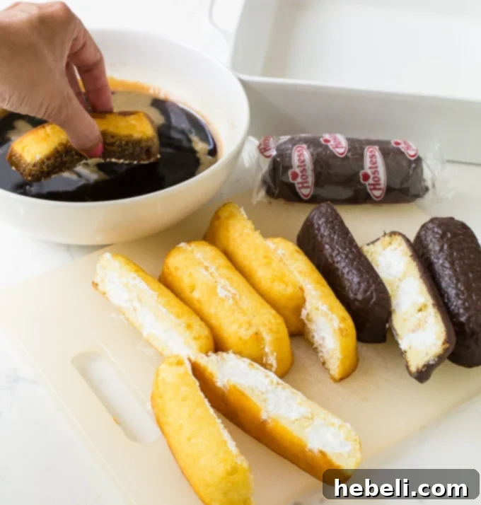 Twinkie Tiramisu prepared in a baking dish, featuring a mix of plain Twinkies and chocolate-covered Twinkies for added depth.
