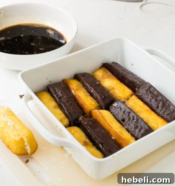Close-up of Twinkies being dipped in espresso mixture, showing the preparation for the tiramisu layers.