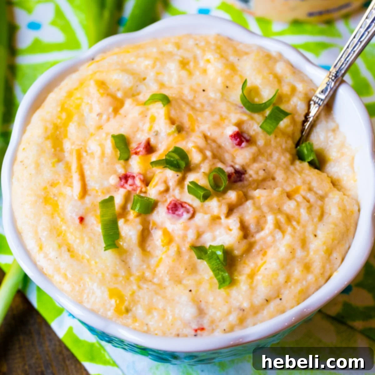 Creamy Pimento Cheese Grits 2 A serving of Pimento Cheese Grits in a rustic bowl with a spoon, ready to be enjoyed.