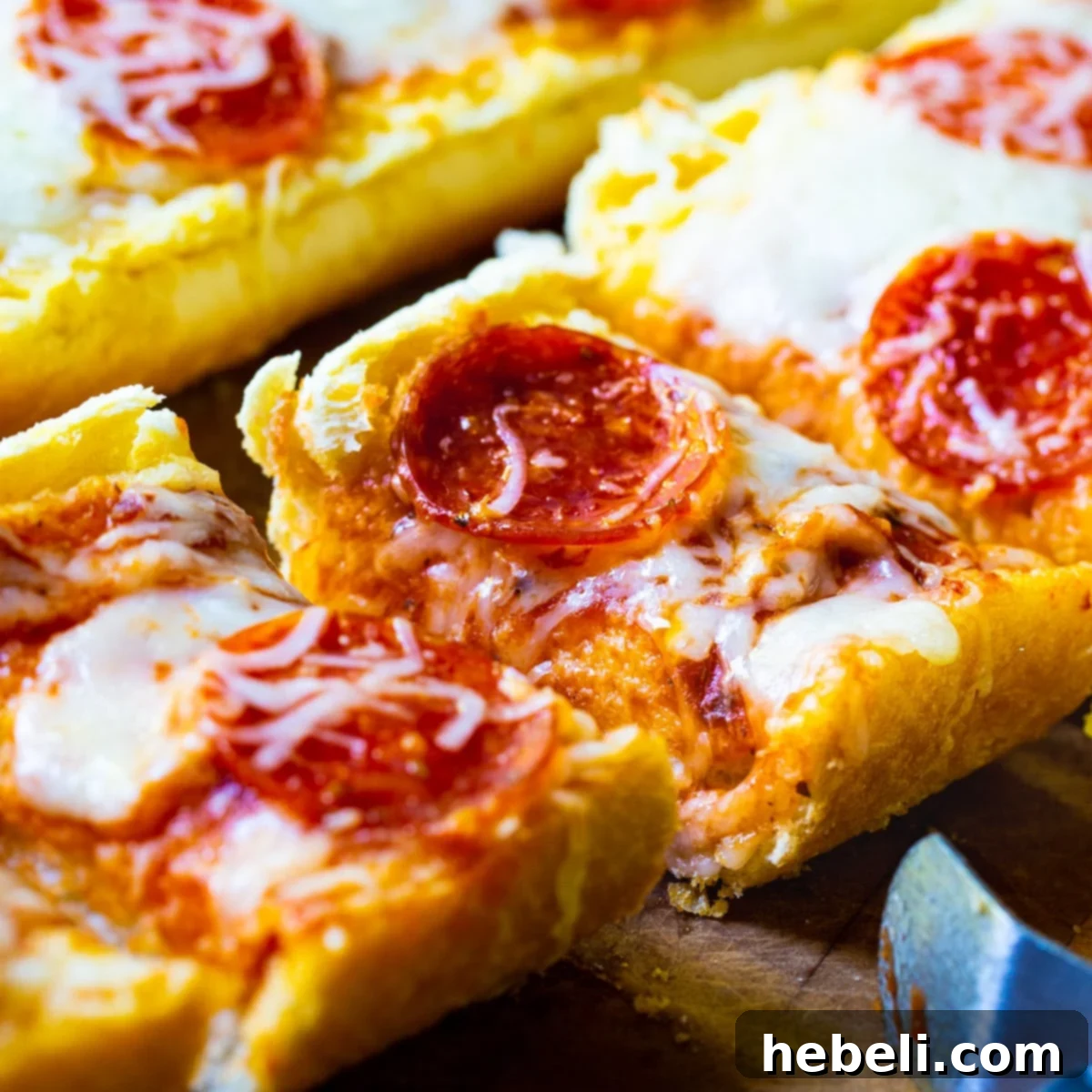 Garlic Bread Pizza cut into slices, showcasing melted cheese and pepperoni on a golden crust.