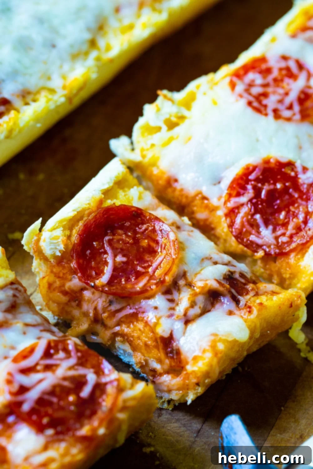 Garlic Bread Pizza cut into slices, close-up to show the delicious texture and toppings.