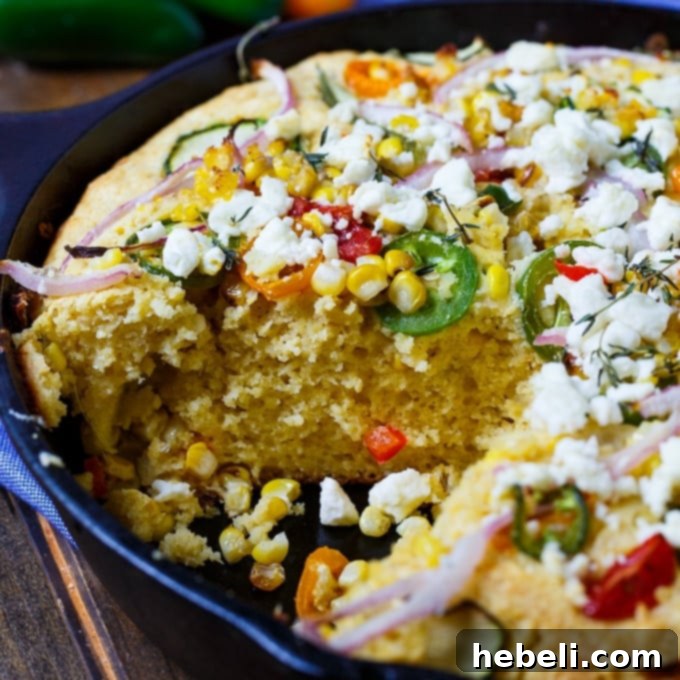 Delicious Farmstand Cornbread, rich with summer vegetables and feta cheese, served in a cast iron skillet.