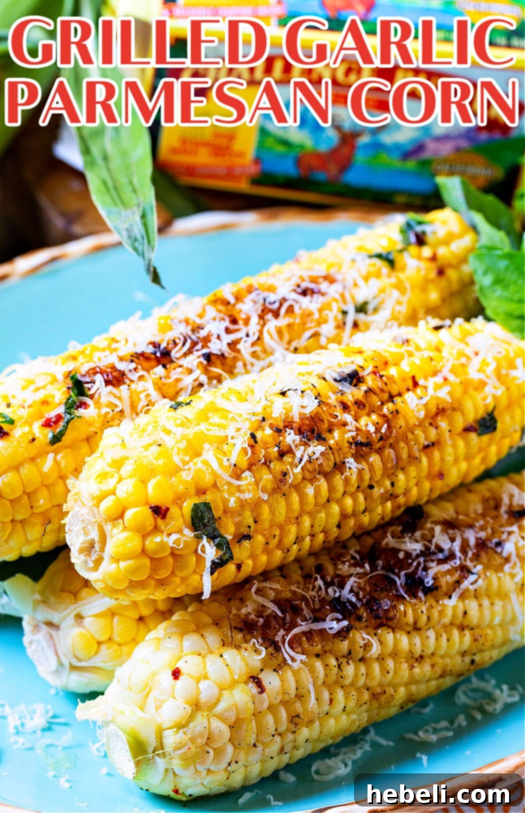 Three ears of Grilled Garlic Parmesan Corn on a beautiful blue serving plate, ready to be enjoyed.