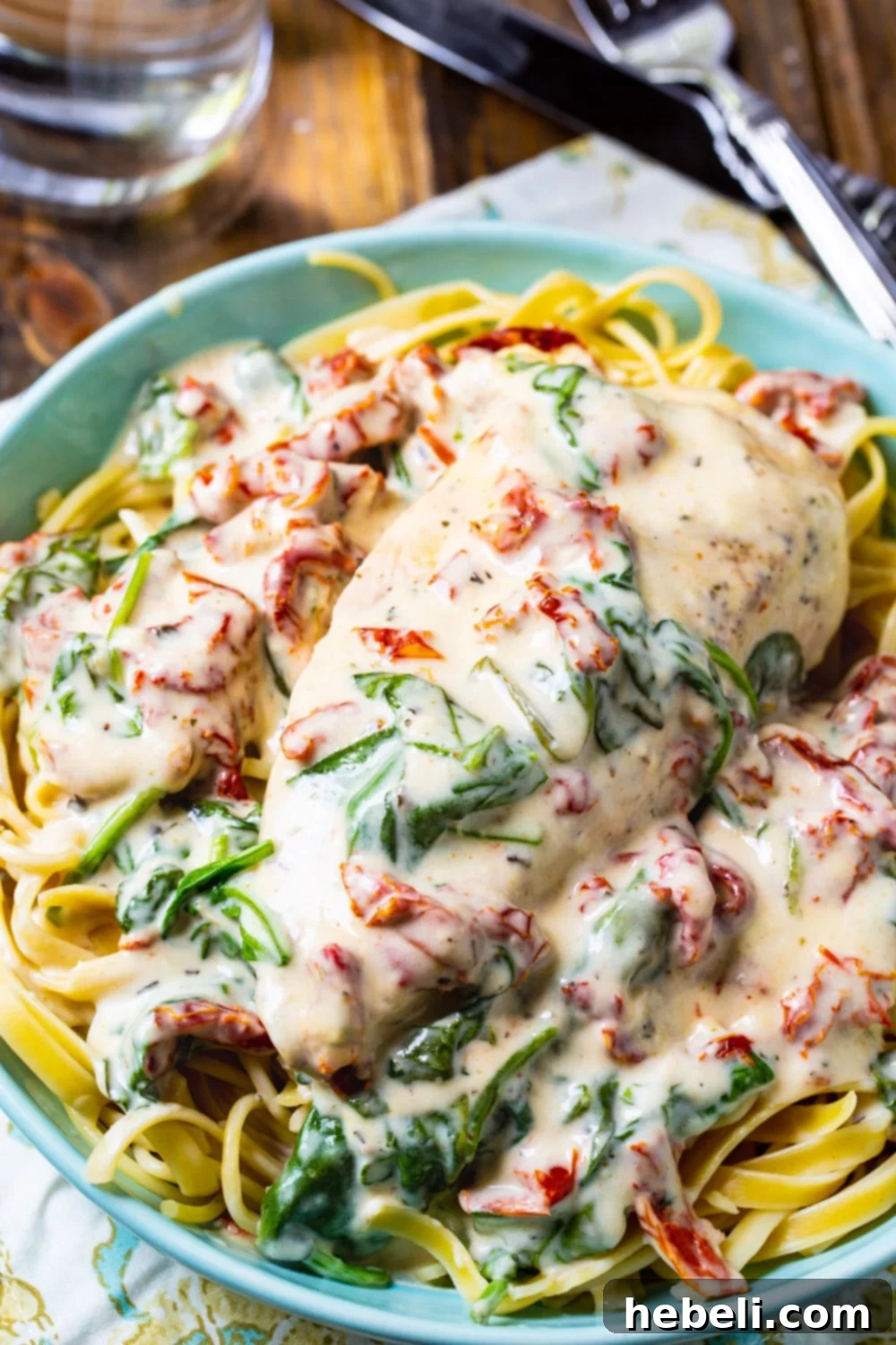 Velvety Slow Cooker Tuscan Chicken 5 Slow Cooker Creamy Tuscan Chicken served elegantly over pasta, ready to be enjoyed.