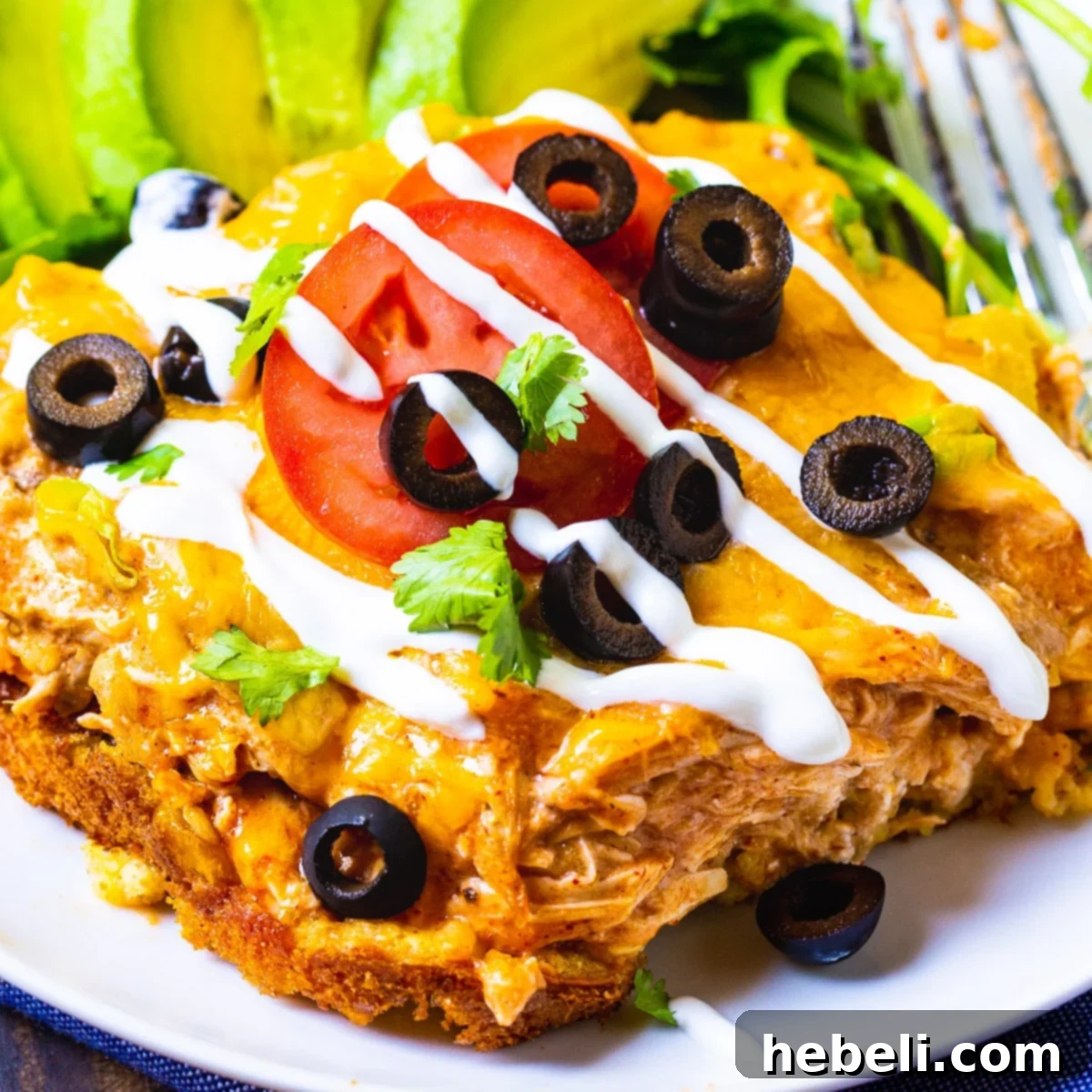 A generous slice of Spicy Chicken Tamale Casserole on a white plate, showcasing the golden cornbread crust and the savory chicken filling, ready to be enjoyed.