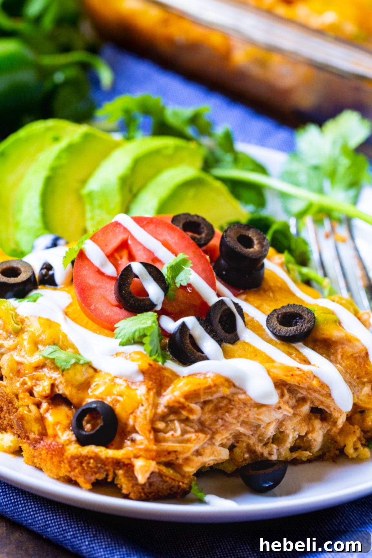 A perfectly portioned slice of Chicken Tamale Casserole, showcasing the distinct layers of cornbread and chicken filling, on a rustic plate.