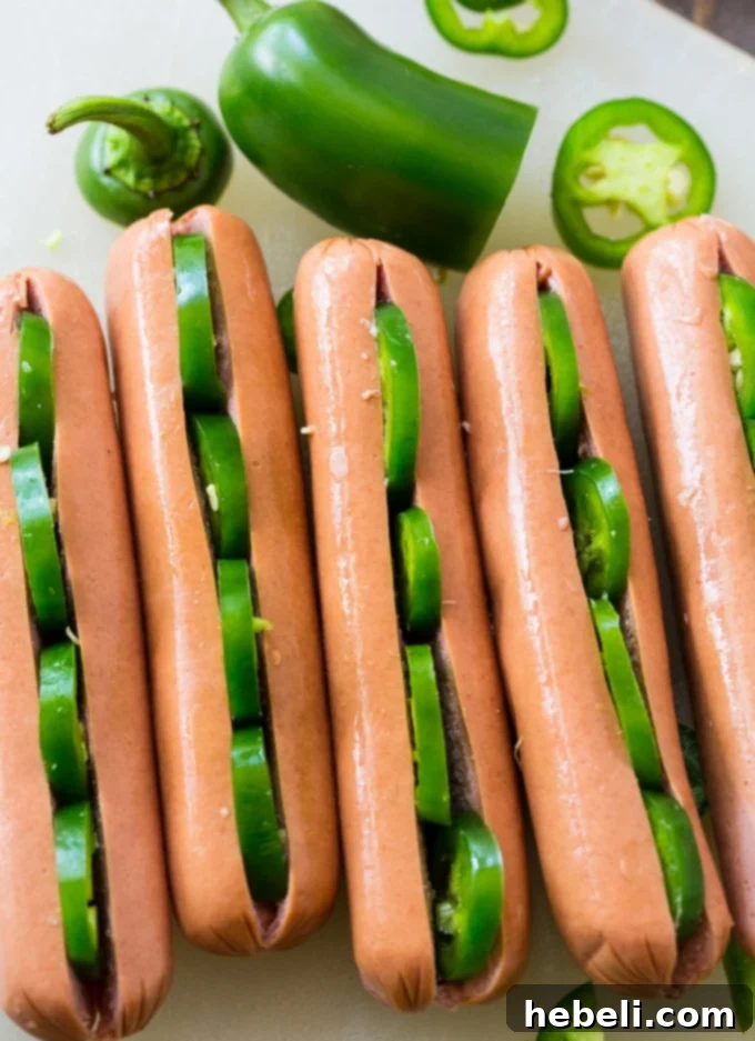 Fiery Jalapeno Franks 3 Jalapeno slices being stuffed into a hot dog