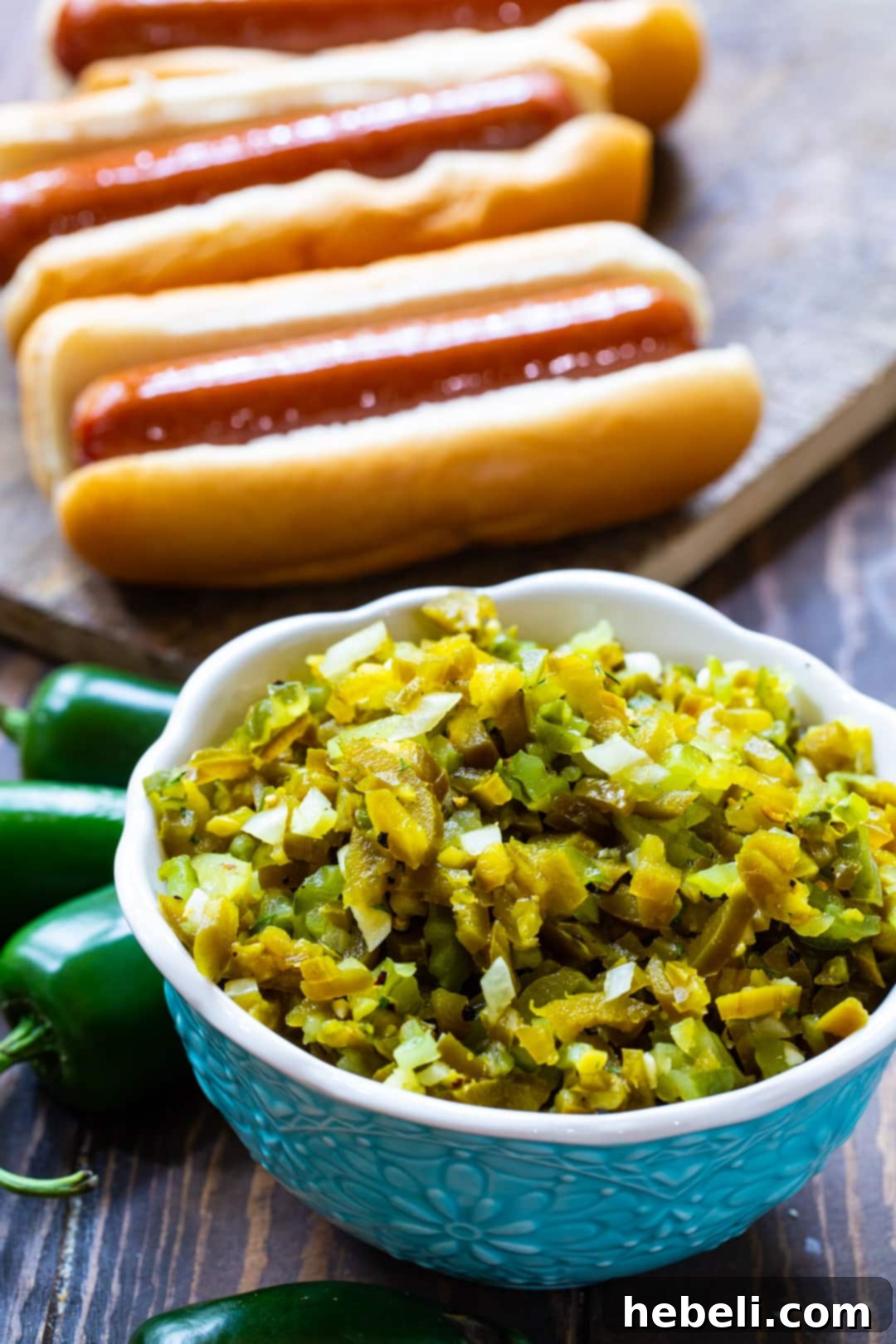 A bowl of vibrant Homemade Jalapeno Relish served alongside perfectly grilled hot dogs, ready for a delicious summer meal.
