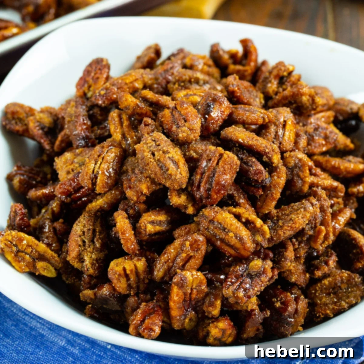A bowl filled with perfectly golden-brown Crock Pot Candied Pecans, ready to be enjoyed.