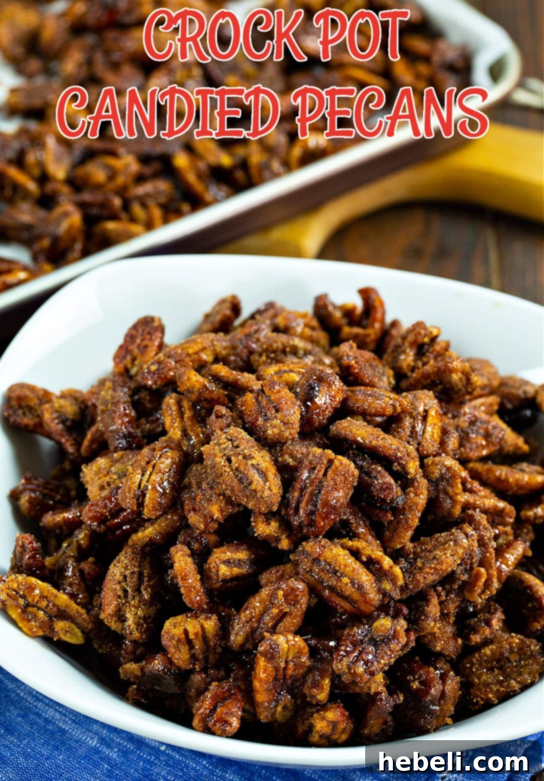 A close-up shot of crispy Crock Pot Candied Pecans in a ceramic bowl, glistening with sugar.