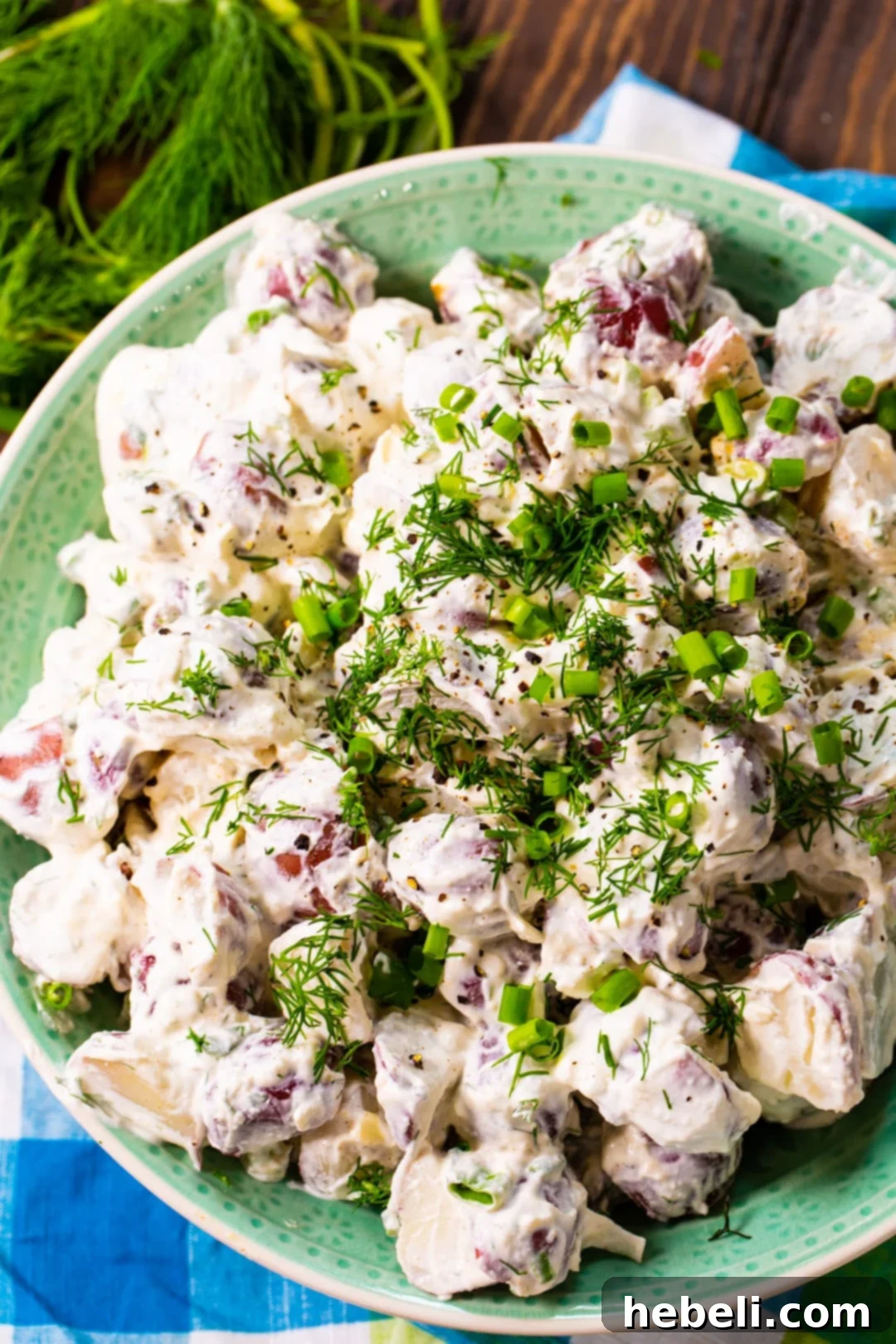 Creamy Dill Potato Salad 4 Overhead shot of Creamy Dill Potato Salad in a large serving bowl, surrounded by fresh ingredients.