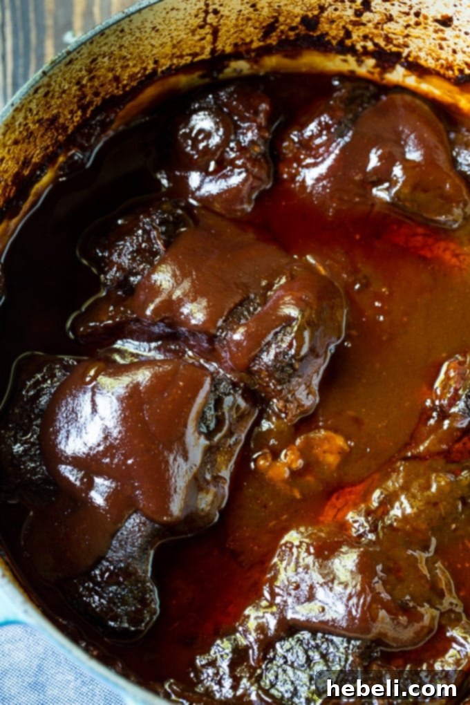 Tender BBQ Pot Roast cooking in a Dutch oven