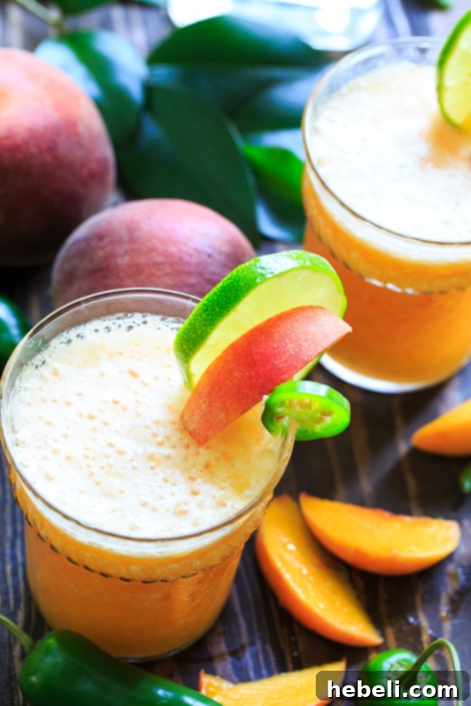 Sweet Heat Peach Margarita 3 Fresh ingredients for Peach Jalapeno Margarita, including sliced peaches, lime, and jalapeños.