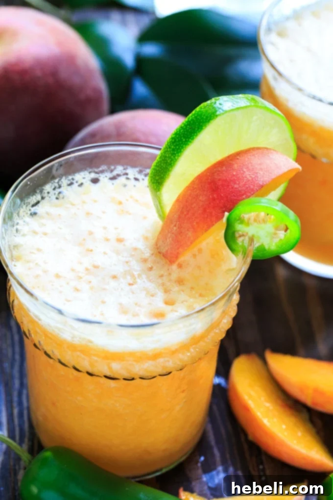 Sweet Heat Peach Margarita 4 A close-up of the Peach Jalapeno Margarita, showing the salt rim and the vibrant color of the drink.