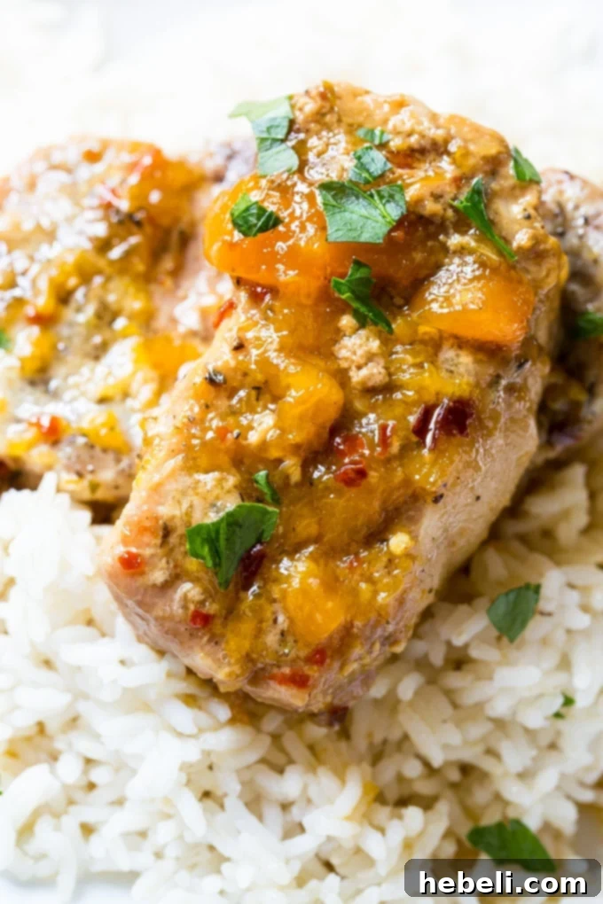Close-up of Slow Cooker Spicy Peach Glazed Pork Chops, highlighting the rich sauce.