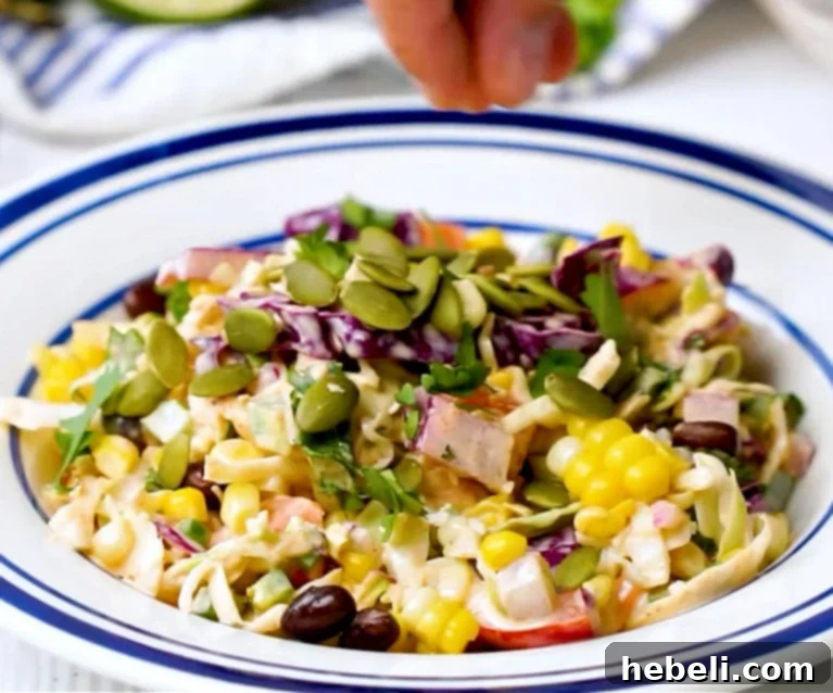 Sprinkling pepitas over the finished Mexican coleslaw for garnish and extra crunch.