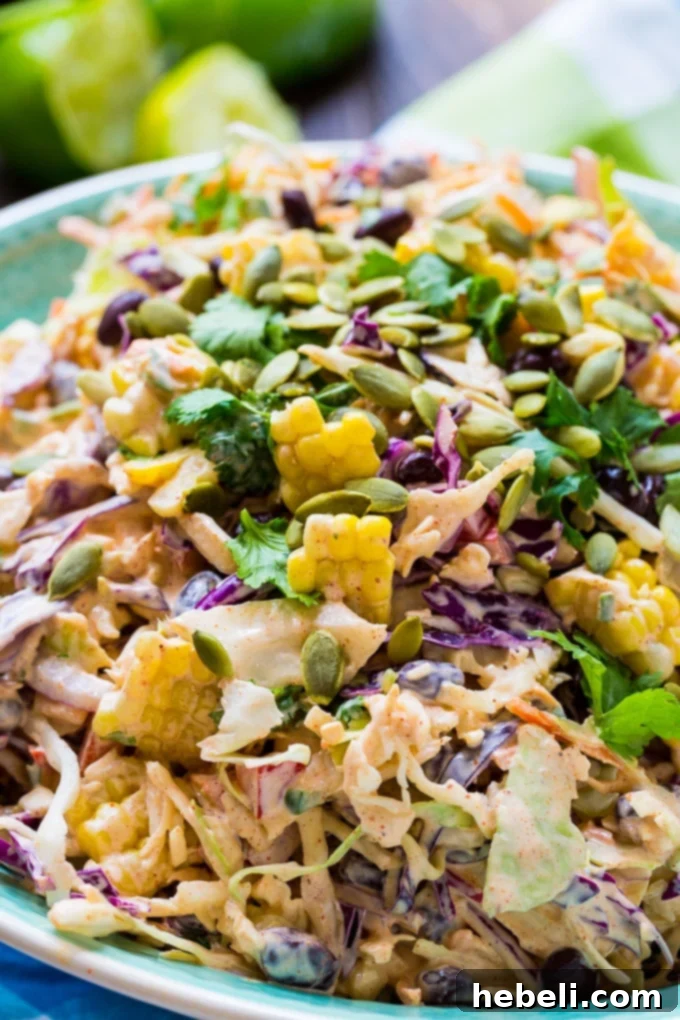 A serving of Mexican Coleslaw featuring a blend of colorful ingredients and a creamy dressing, highlighted with a sprinkle of pepitas.