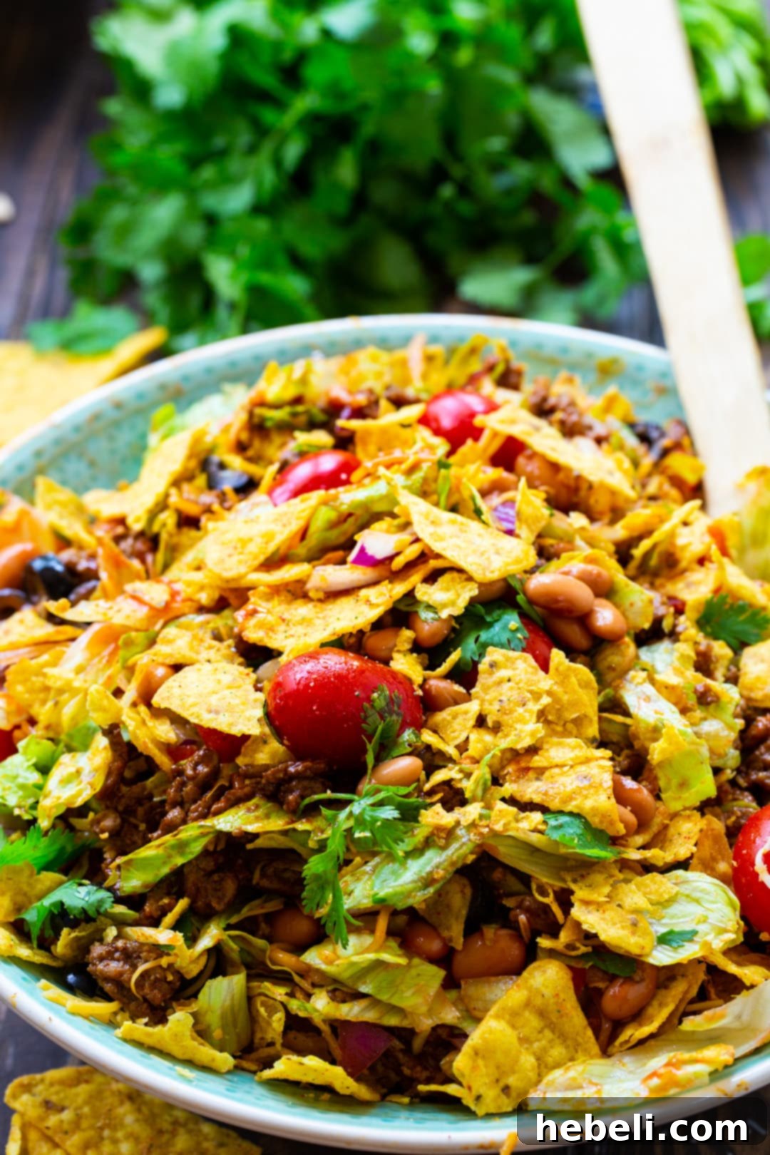 A close-up view of Dorito Chopped Salad in a clear serving bowl, showing the vibrant colors and crunchy texture.