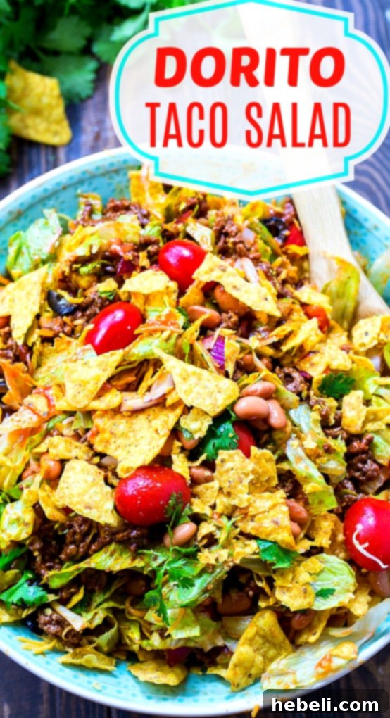 A vibrant Dorito Taco Salad served with a side of sour cream, showing the rich colors and textures.