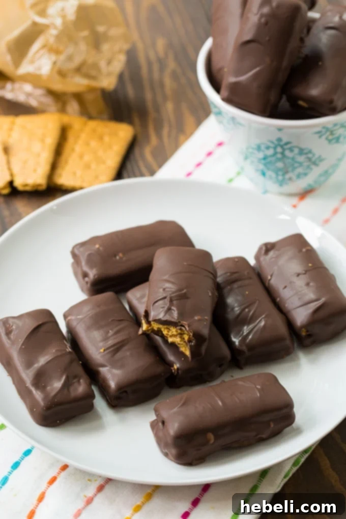 Decadent Chocolate Peanut Butter Graham Bites 6 A batch of freshly dipped Chocolate Peanut Butter Grahams setting on parchment paper.