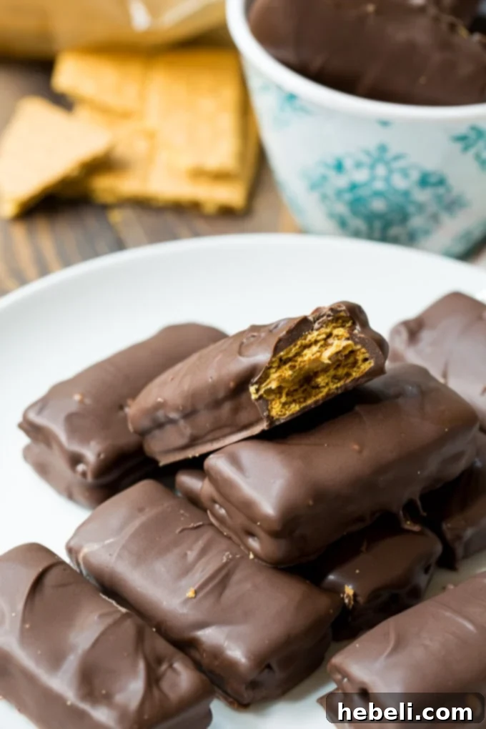Decadent Chocolate Peanut Butter Graham Bites 7 Overhead view of multiple peanut butter stuffed graham cracker sandwiches coated with smooth chocolate.