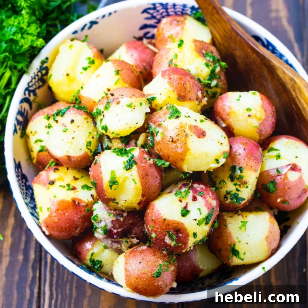 Buttered Parslied Potatoes in a serving bowl, garnished with fresh parsley.