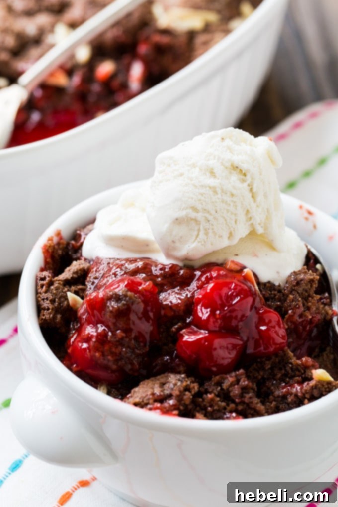 A close-up shot of the cobbler's golden-brown, textured biscuit topping.
