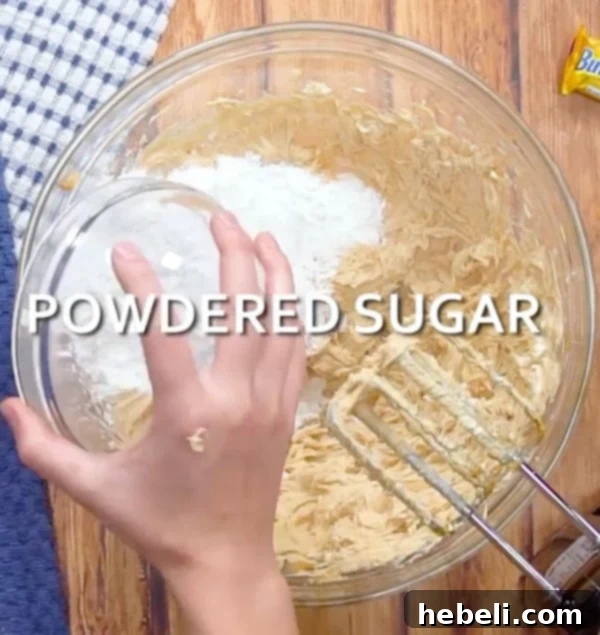 Adding powdered sugar to the mixing bowl.
