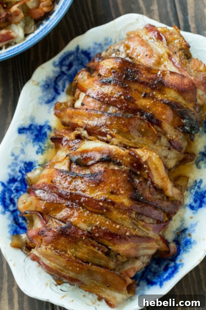 Close-up of Maple Glazed Pork Loin wrapped in crispy bacon slices.