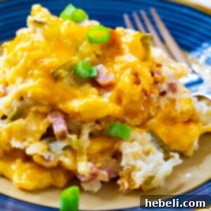 A finished dish of ham and cheese hash brown casserole on a plate, garnished and ready.