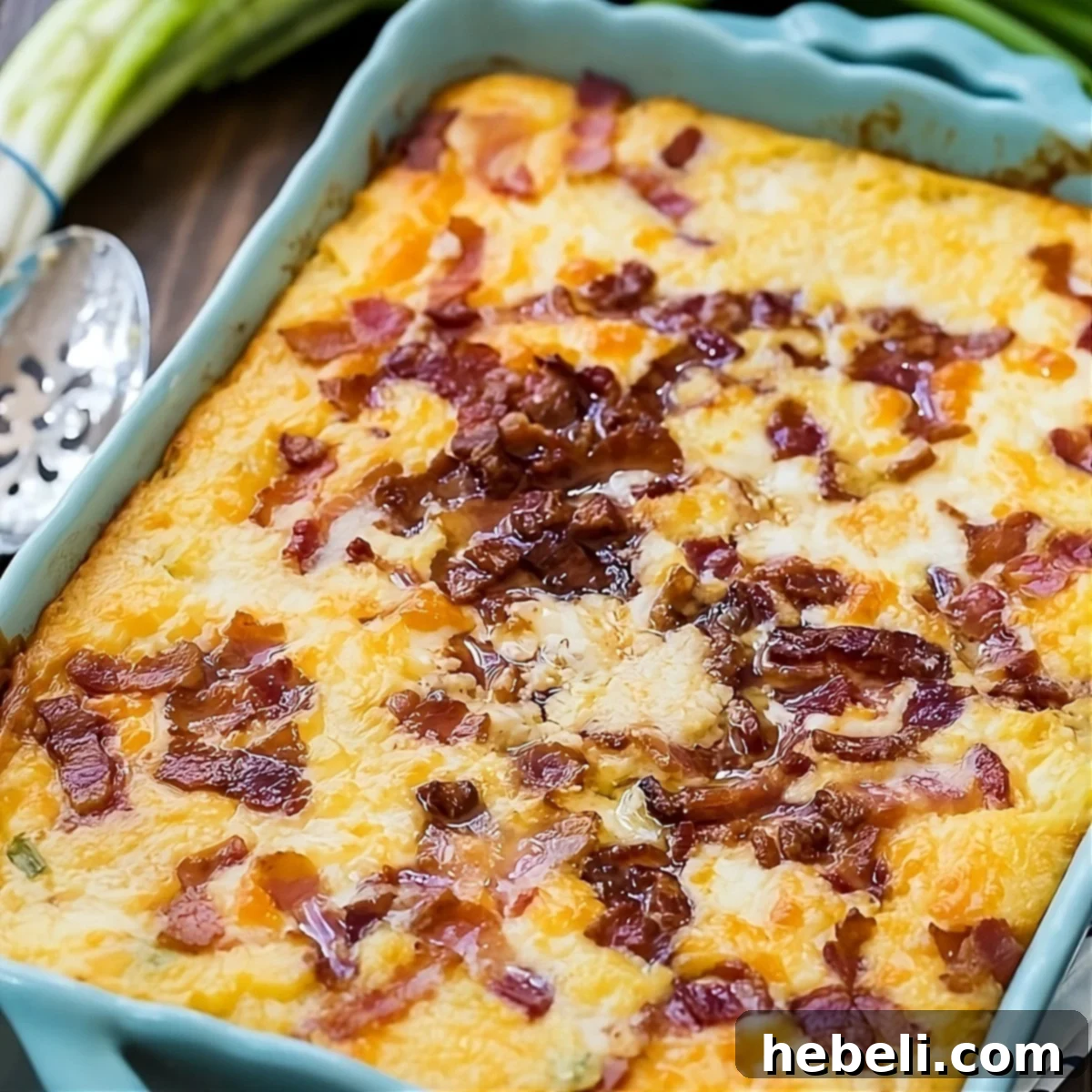 Savory Cheesy Bacon Grits Bake 2 A delicious Cheese and Bacon Grits Casserole in a baking dish, ready to be served, with crispy bacon bits visible on top.