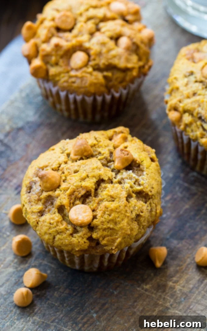 A stack of golden Pumpkin Butterscotch Muffins, showcasing their appealing texture and rich color.