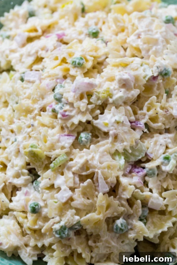Horseradish Zing Pasta Salad 4 A large serving bowl of Spicy Horseradish Pasta Salad, glistening with creamy dressing and ready for a summer gathering.