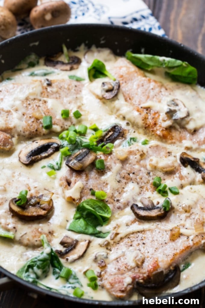 Delicious Creamy Parmesan Pork Chops, generously seasoned with garlic and herbs, glistening with flavor, ready to be cooked to perfection.
