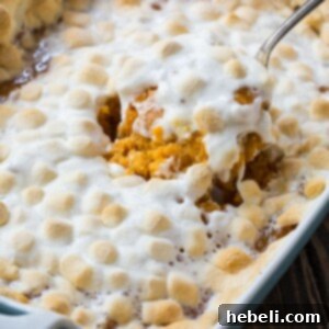 Sweet Potato Casserole with gooey marshmallow topping in a festive serving dish.