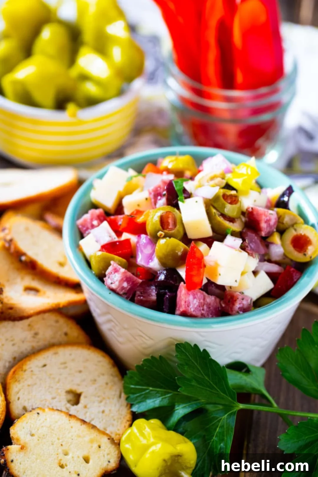 Dip in a small bowl surrounded by chips and fresh vegetables.