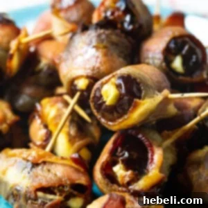 Close-up of a single Bacon Wrapped Stuffed Date on a white plate.