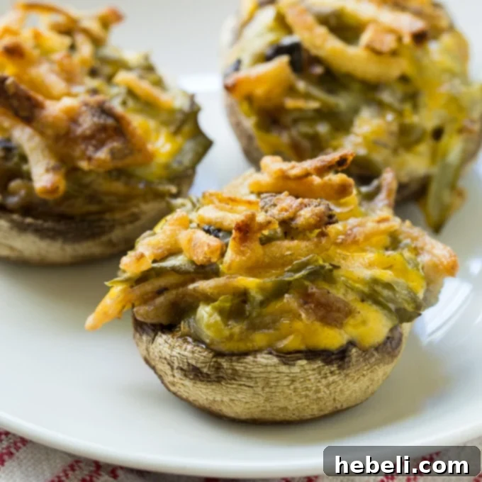 Green Bean Casserole Mushroom Bites 2 Green Bean Casserole Stuffed Mushrooms on a elegant white serving platter, garnished for holiday presentation