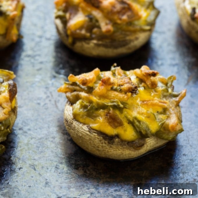Green Bean Casserole Mushroom Bites 5 A selection of fresh white mushrooms arranged on a cutting board, some already cleaned and stems removed, ready for stuffing