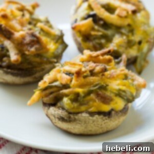 Green Bean Casserole Mushroom Bites 6 A close-up of a finished Green Bean Casserole Stuffed Mushroom, garnished and ready to serve, highlighting its golden crust.
