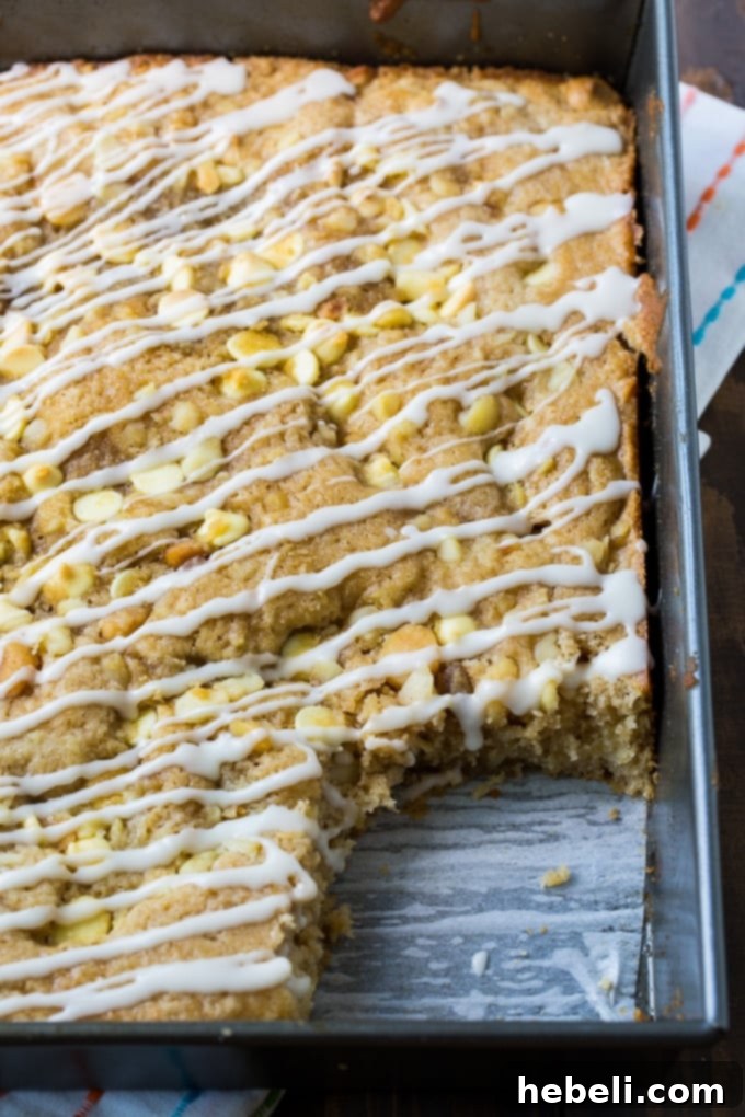 Slice of White Chocolate and Macadamia Nut Coffee Cake with a generous vanilla glaze.