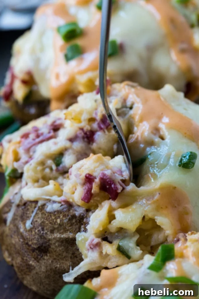 A close-up of beautifully Stuffed Reuben Potatoes, showing the rich filling and melted cheese