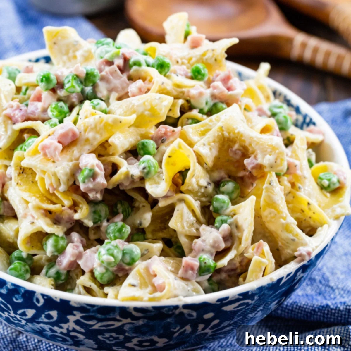 Ranch Noodles with Ham in a serving bowl, creamy with peas, ham, ranch dressing, and Parmesan cheese.