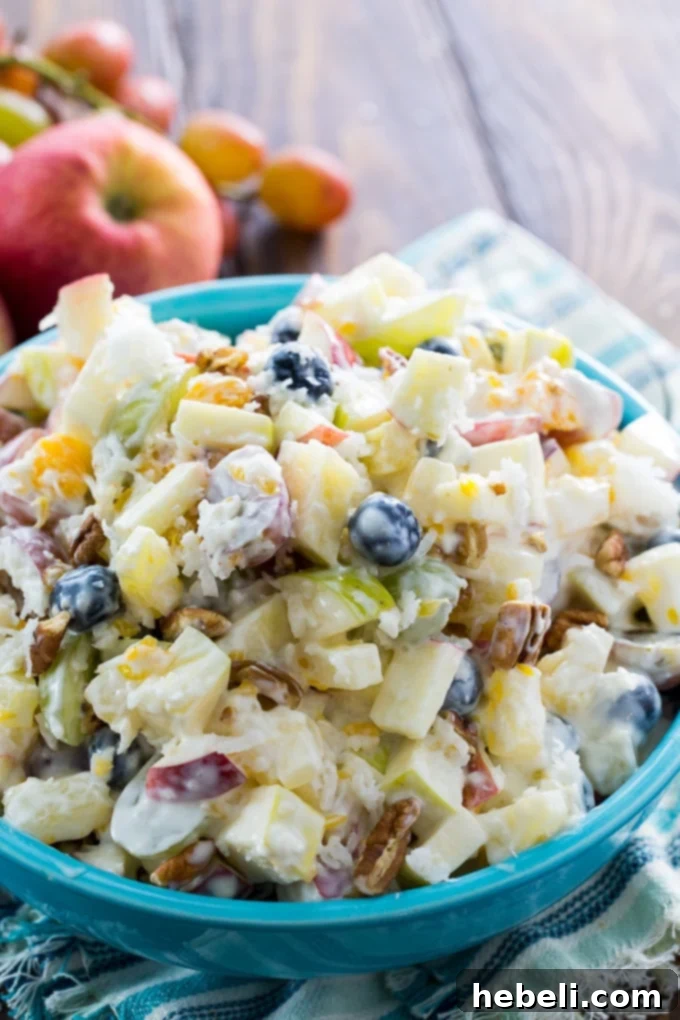 Silky Fruit Ambrosia 3 Close-up of Creamy Fruit Salad with visible apples, red and green grapes, pineapple chunks, and blueberries, demonstrating its rich texture and colorful presentation.