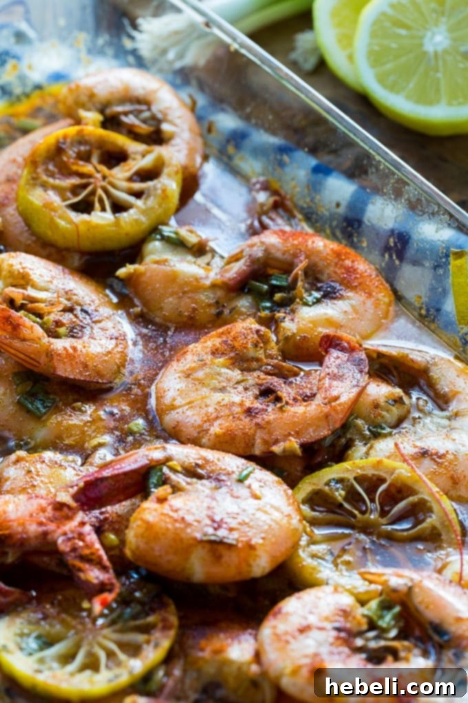 New Orleans Style BBQ Shrimp cooked in a baking dish with bay leaves and lemon slices